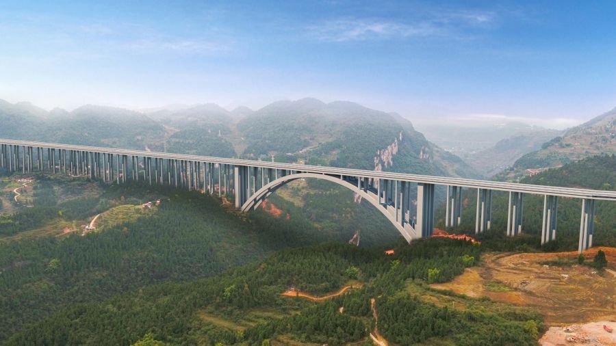 古金高速水落河特大橋，全長1701米，為上承式鋼筋混凝土懸臂澆筑拱橋，跨徑335米，超過世界已知同類型最大跨徑拱橋---美國胡佛水壩大橋332m的跨徑，穩(wěn)居世界第一。該橋首創(chuàng)數(shù)字化智能橋梁建設、管理、施工作業(yè)體系，在結構上為大跨度混凝土拱橋的設計提供基礎和參考，為山區(qū)寬幅薄壁箱型拱橋的懸臂施工提供技術經驗。.jpg